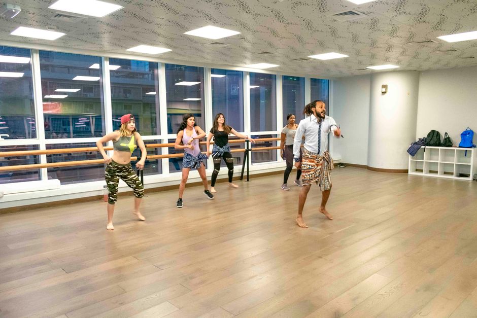 Vibrant dance class session led by an instructor in a modern studio with diverse participants.